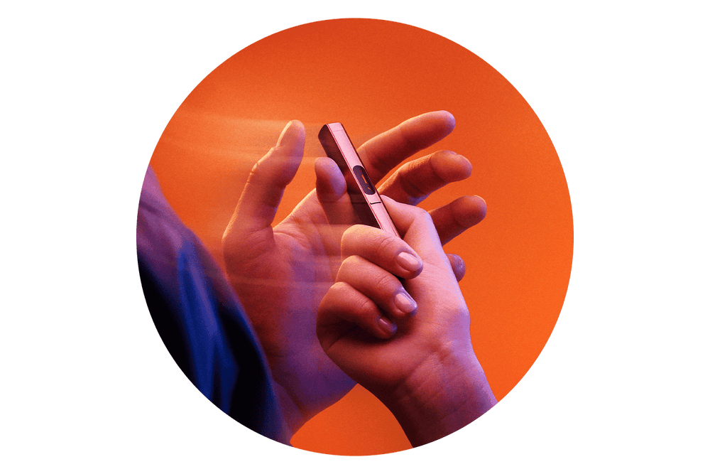 A hand holds a vape pen with fingers poised to use it, set against an orange background. Motion blur suggests movement, giving the image a dynamic feel.