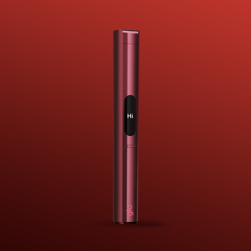 The slim, metallic red glo™ HILO Plus Replacement Pen stands upright on a red gradient background. Its small screen displays “Hi,” while “glo” appears near the base, highlighting this stylish and customizable replacement pen.