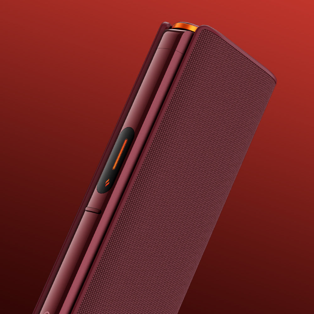 A close-up of a modern burgundy smartphone in a stylish glo™ HILO Plus Sleeve, featuring textured premium fabric, orange accents, and a partially visible hinge against a gradient red background.