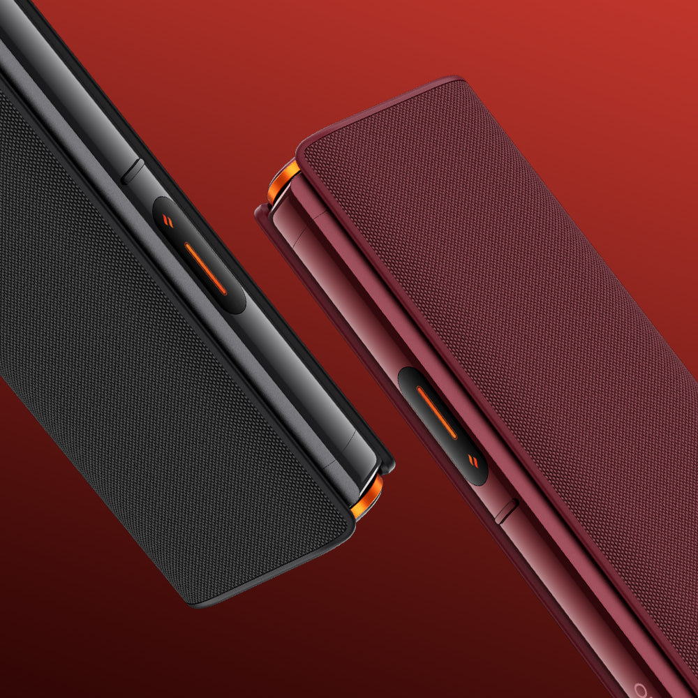 Two modern, rectangular glo™ HILO Plus Sleeve wireless speakers—one black and one dark red—are side by side on a red gradient background, each with a premium fabric cover that accentuates their sleek design and textured surfaces.