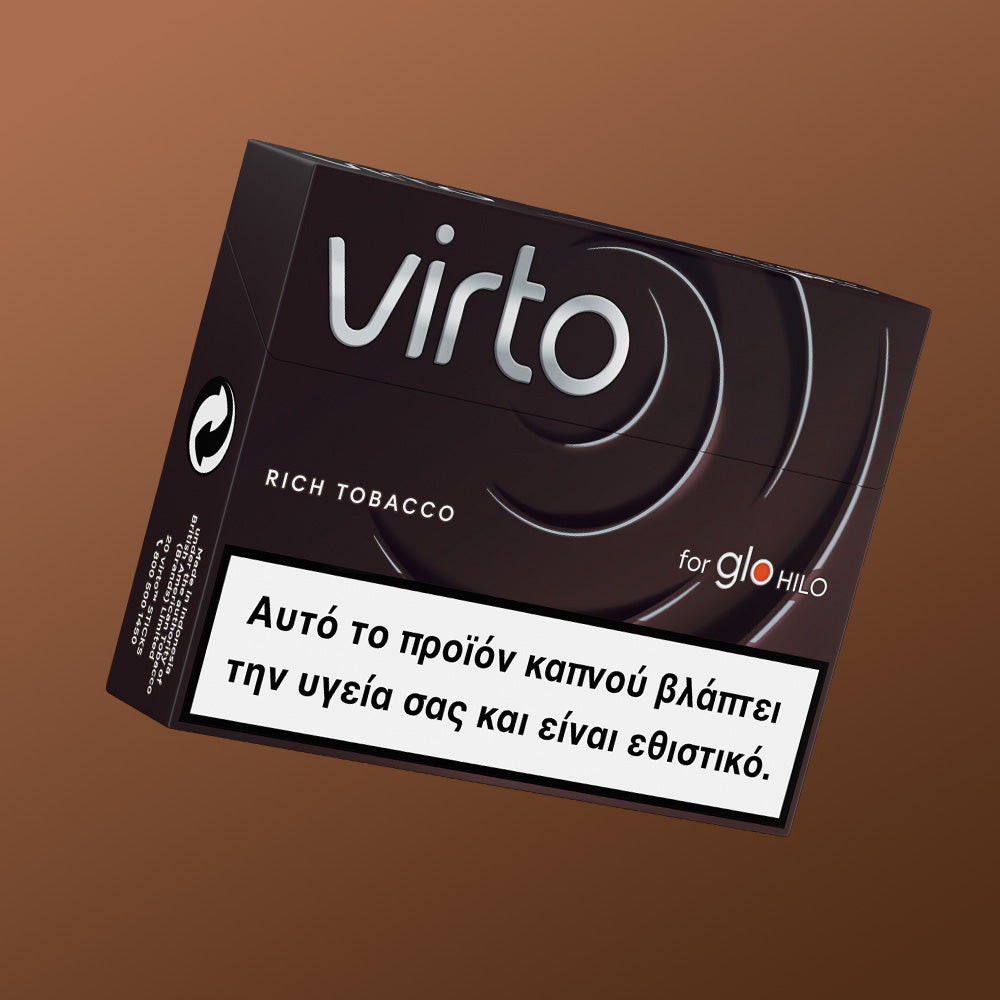 Ένα μαύρο κουτί του προϊόντος virto™ Rich Tobacco για το glo HILO, στο οποίο εμφανίζεται μια ελληνική προειδοποιητική ετικέτα που αναφέρει ότι ο καπνός βλάπτει την υγεία και προκαλεί εθισμό, πάνω σε καφέ φόντο.