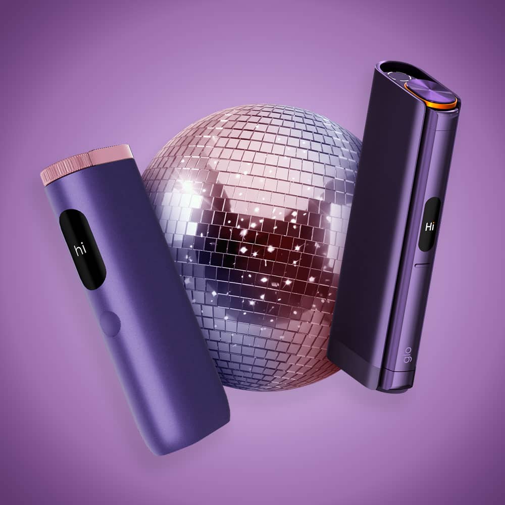 Two sleek, purple electronic devices with hi on their displays are positioned beside a shiny disco ball, set against a purple background.