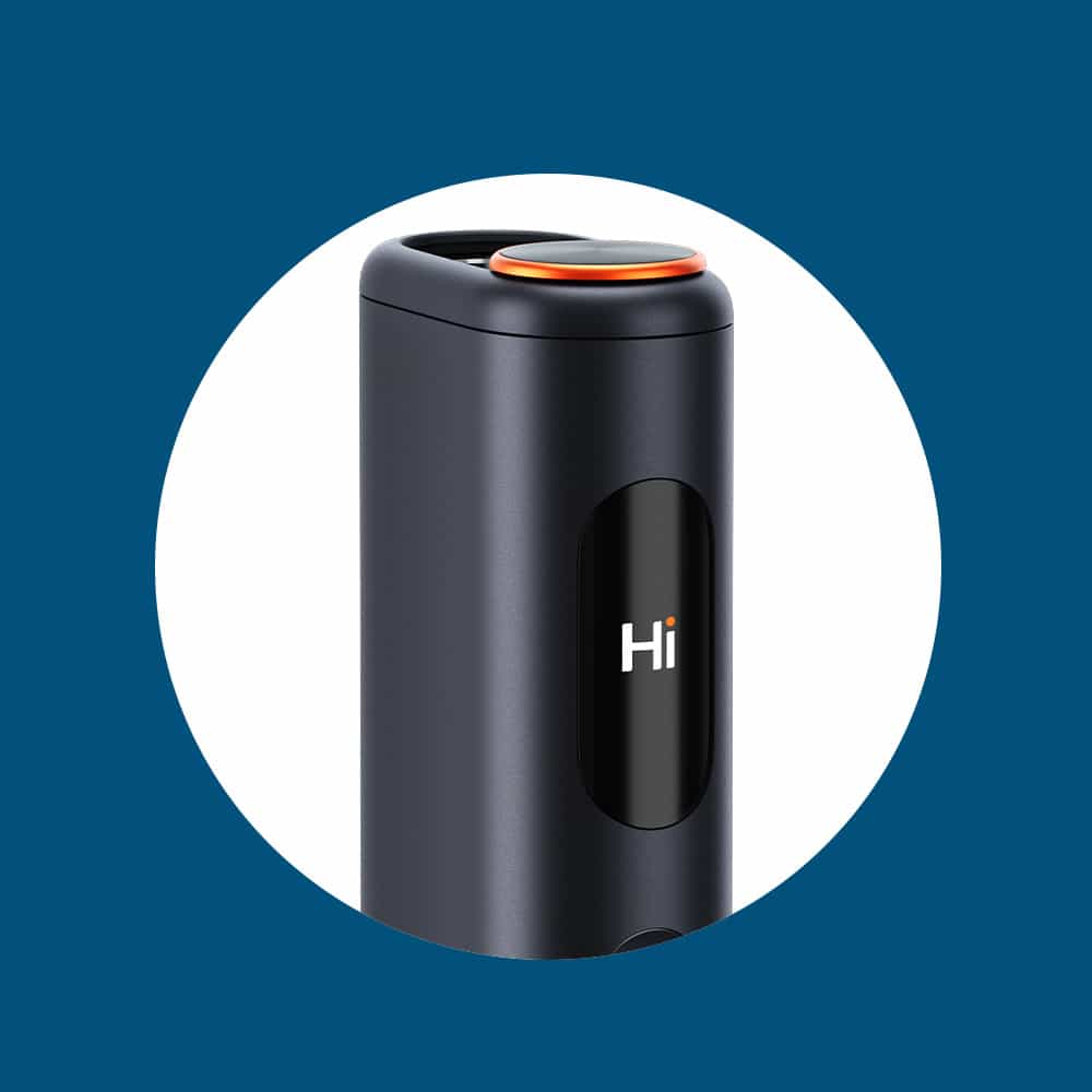 A close-up of a sleek, black cylindrical device with a small screen displaying the word “Hi” and an orange-edged button on top, shown against a blue background with a white circle.