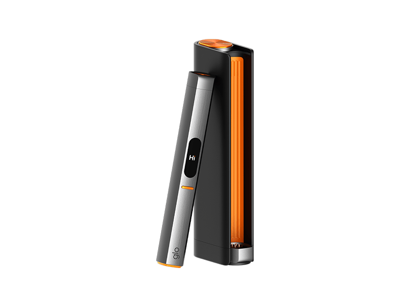 Μια κομψή συσκευή glo™ HILO Plus Limited Edition Design, με ασημί και μαύρο σώμα, πορτοκαλί λεπτομέρειες και το μήνυμα «Hi» στη μικρή οθόνη της, βρίσκεται δίπλα στη συμβατή μαύρη και πορτοκαλί θήκη φόρτισης.
